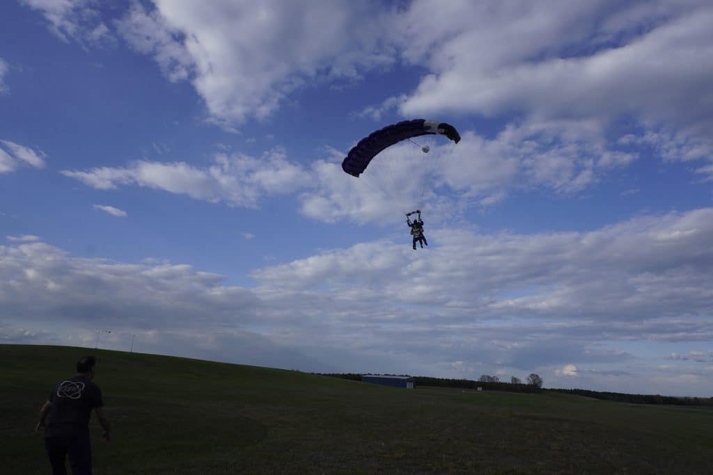 two people with parachute landing on grassy field in Franklinton, NC